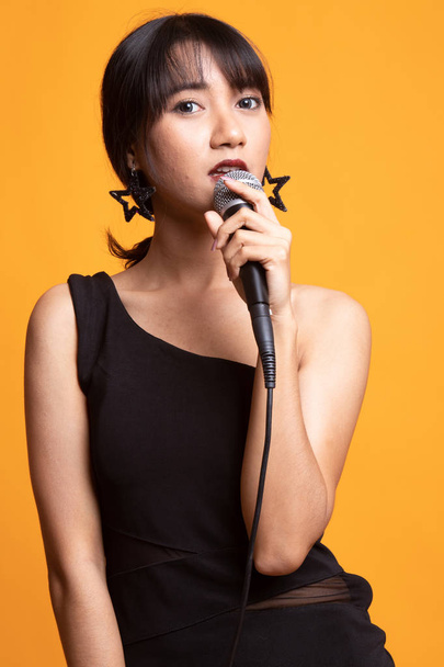 Hermosa joven mujer asiática cantante cantar con micrófono
 - Foto, Imagen