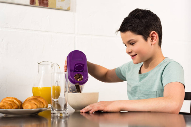 mosolygó preteen Boy reggelizik reggel a konyhában - Fotó, kép