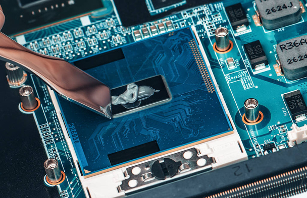 Applicazione della pasta termica sul chip del processore portatile per il raffreddamento di alta qualità
. - Foto, immagini