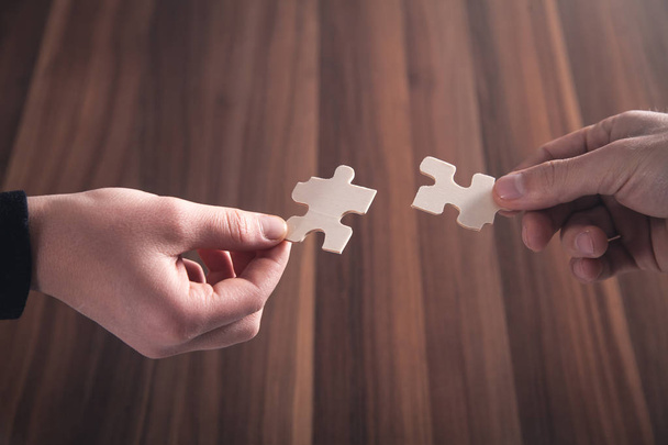 Hand holding jigsaw puzzle piece. Solution, Success, Teamwork - Photo, Image