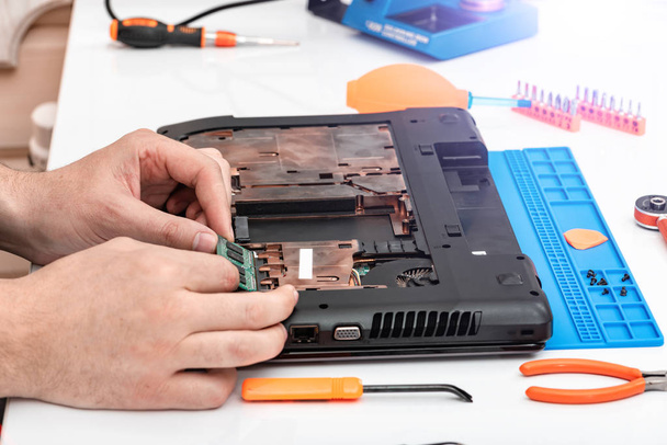Інженер робить демонтаж оперативної пам'яті для розбирання і ремонту ноутбука. - Фото, зображення