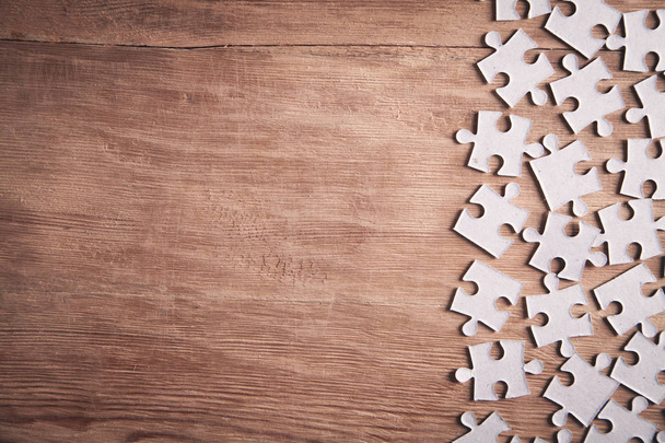 Pieces of the jigsaw puzzles on wooden background.  - Fotó, kép