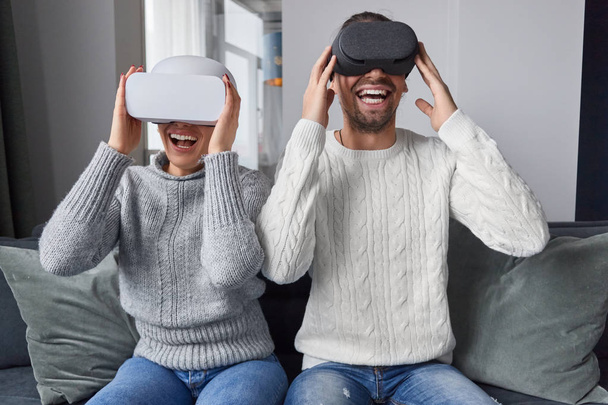 Excited couple watching movie in VR helmets - Fotó, kép