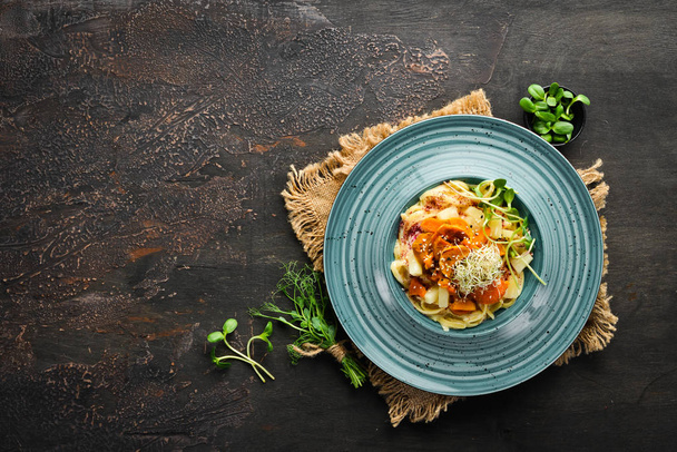 Pasta with pineapple and carrots. In the plate. Top view. Free space for your text. Rustic style. - Фото, зображення