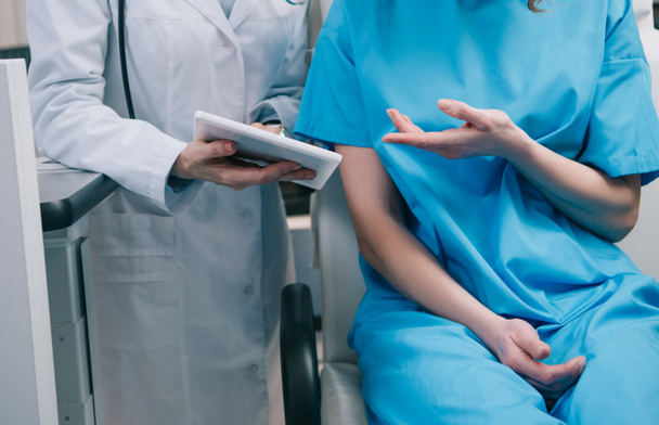 částečný pohled na doktora v bílém plášti s digitálním tabletem s diagnózou pacienta - Fotografie, Obrázek