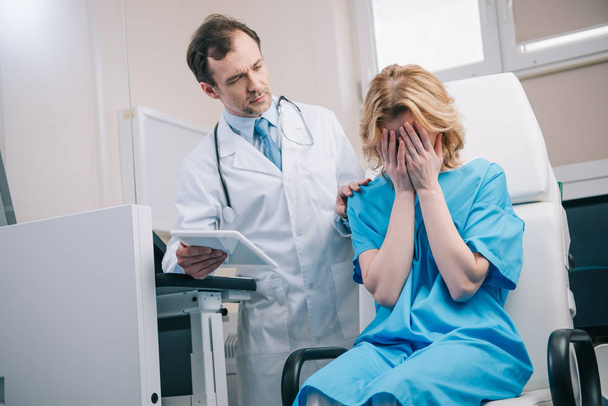 mulher chorando sentado em poltrona perto médico segurando tablet digital
 - Foto, Imagem