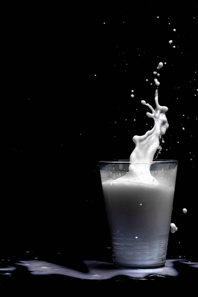 Šplouchání mléka izolované na černém pozadí - Fotografie, Obrázek