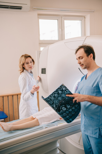 放射線科医が患者の診断中にctスキャナを操作しながら断層撮影診断を見ている医師 - 写真・画像