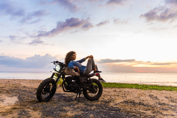 Жінка-велосипедистка за кермом гонщика кафе мотоцикл
 - Фото, зображення