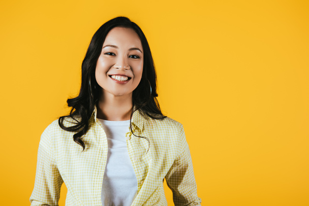 smiling brunette asian girl isolated on yellow - Fotó, kép