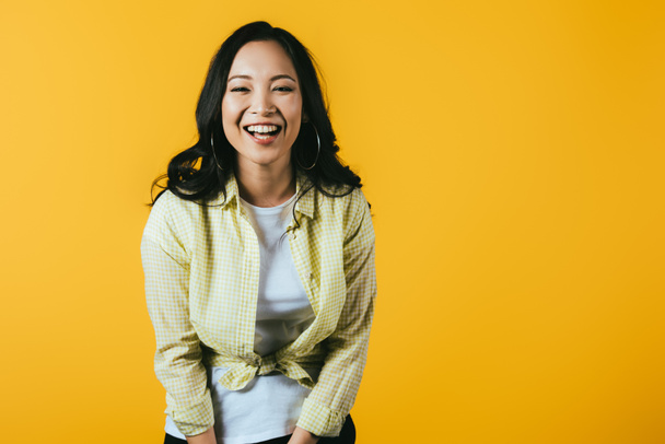 cheerful brunette asian girl isolated on yellow - Фото, изображение