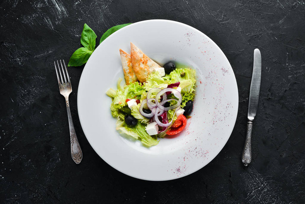 Greek salad. Vegetable salad with feta cheese, olives and cherry tomatoes. In the plate. Top view. Free space for your text. Rustic style. - Foto, imagen