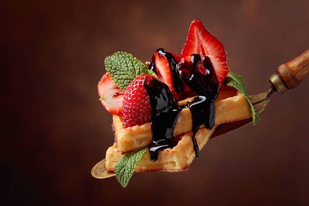 Waffles with strawberries, mint and chocolate sauce. - Fotó, kép