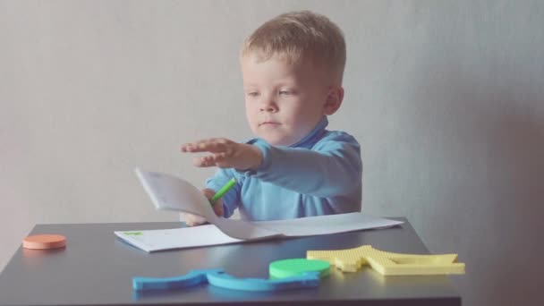 two year old boy is drawing with marker at album - Video
