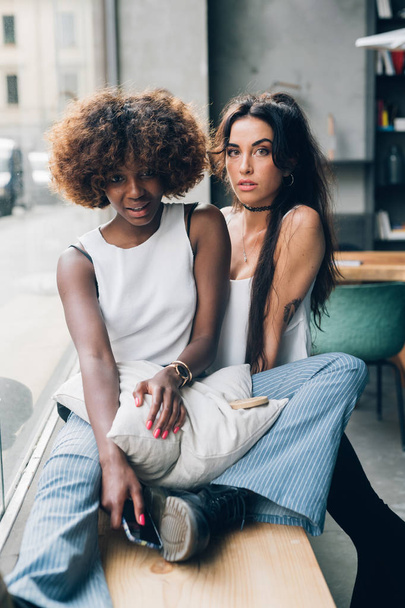 young women sitting on bench in modern bar  - Photo, image
