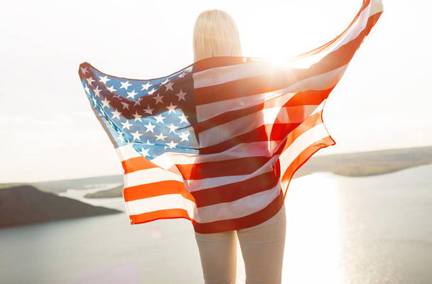 Patriotic holiday. 4th of July, Independence day. Beautiful woman holding American Flag. - Photo, Image