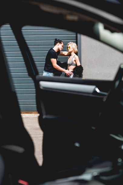 selective focus of stylish man and beautiful girl posing near garage door - Fotó, kép