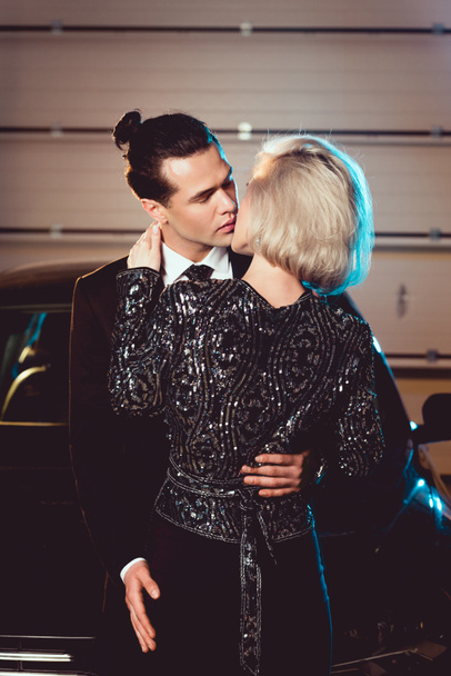 stylish couple in formal wear kissing near car - Valokuva, kuva