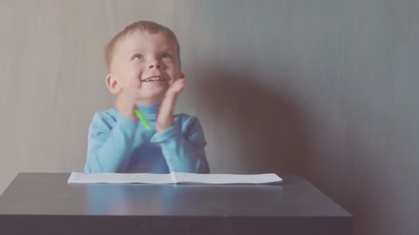two year old boy is drawing with marker at album - Footage, Video