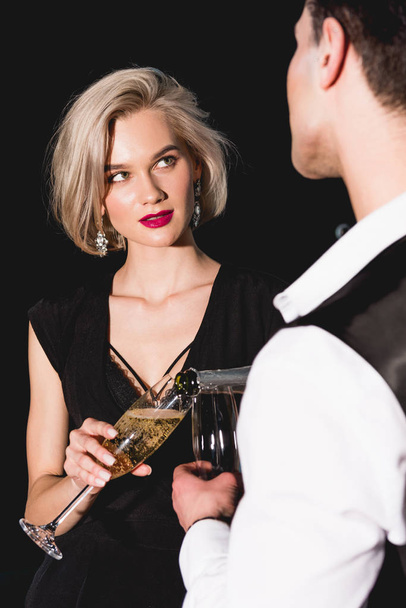 man pouring champagne for beautiful fashionable young woman  - Foto, afbeelding