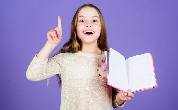 Got great idea. Happy little girl holding open idea book and keeping finger raised. Smiling small child having an idea. Idea came into her head, copy space - Fotoğraf, Görsel