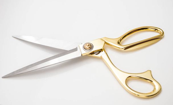 golden metal scissors for cutting lie on a white background - Foto, imagen