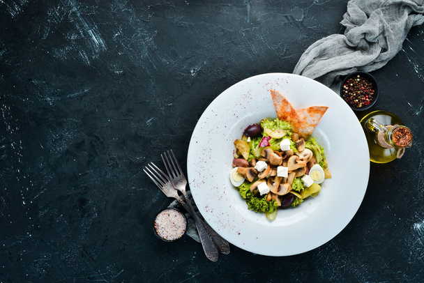Vegetable salad with mushrooms, olives and feta cheese. In the plate. Top view. Free space for your text. Rustic style. - 写真・画像