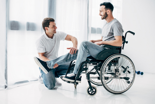 mosolygós fizioterápiás masszírozó lábát fogyatékos ember kerekesszékes  - Fotó, kép