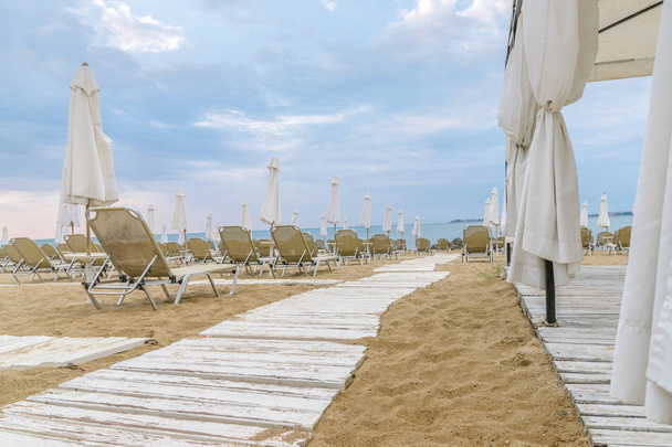 Krzesła i parasole na pięknej plaży w Słonecznym Brzegu na wybrzeżu Morza Czarnego w Bułgarii. - Zdjęcie, obraz