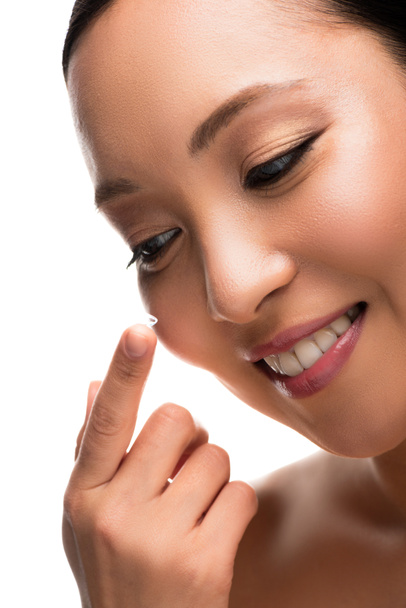 усміхнена азіатська жінка тримає контактну лінзу, ізольована на білому
 - Фото, зображення