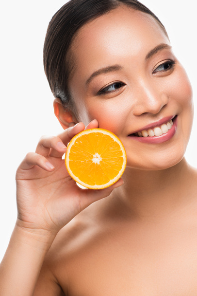 attractive cheerful asian girl holding orange, isolated on white - Foto, immagini