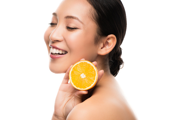 beautiful smiling asian woman holding orange, isolated on white - Foto, immagini