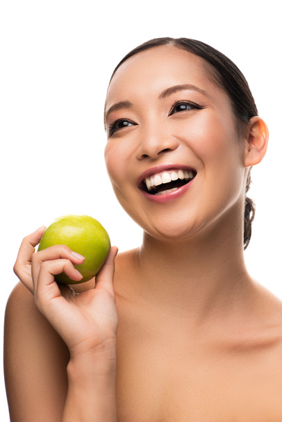 atractivo asiático chica riendo y sosteniendo verde manzana, aislado en blanco
 - Foto, Imagen