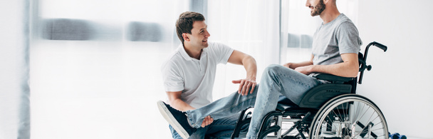 病院で車椅子の患者の理学療法士マッサージ脚のパノラマショット - 写真・画像