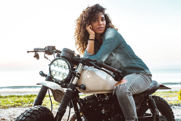 Female biker driving a cafe' racer motorbike - Valokuva, kuva
