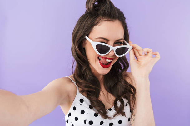 Portrait of slim pin-up woman 20s in retro sunglasses smiling wh - Foto, afbeelding