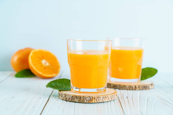Fresh orange juice on wood background - Fotoğraf, Görsel