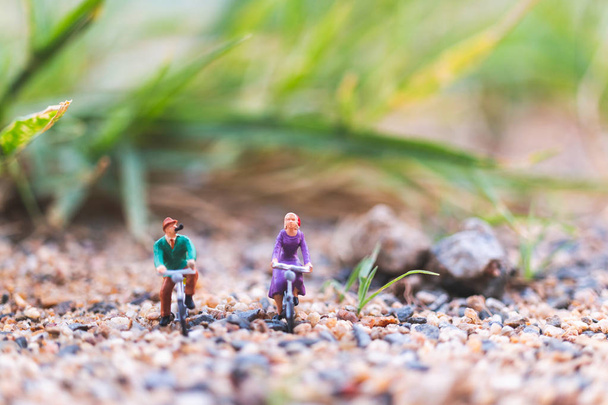 Miniaturní lidé: Cestovatelé jedoucí na kole na písku - Fotografie, Obrázek
