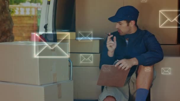 Digital composite of Caucasian delivery man counting packages on a van while sitting. Envelopes can be seen moving in the foreground - Filmati, video