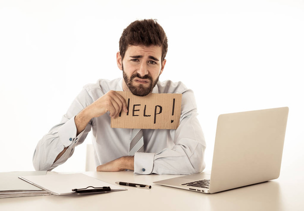 Desperate caucasian businessman with laptop computer suffering stress at workplace holding sign asking for help looking sad angry and overworked. In People Business Overwork and Deadline Pressure. - Photo, image