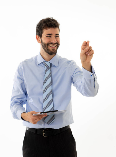 Young attractive businessman pointing at copy space as using a virtual screen. Smiling feeling confident and successful. In people business education, success and new technology at work concept. - Photo, image