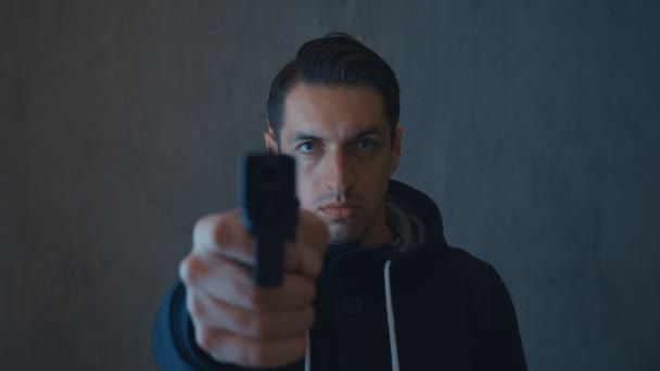 Criminoso perigoso apontando uma arma para a câmera em um escuro
 - Filmagem, Vídeo