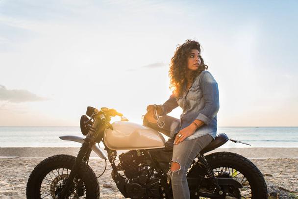 Female biker driving a cafe' racer motorbike - Foto, immagini
