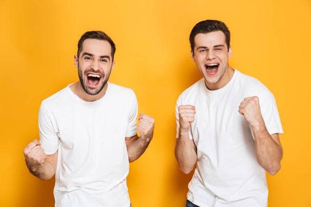 Two cheerful excited men friends wearing blank t-shirts - Foto, Bild