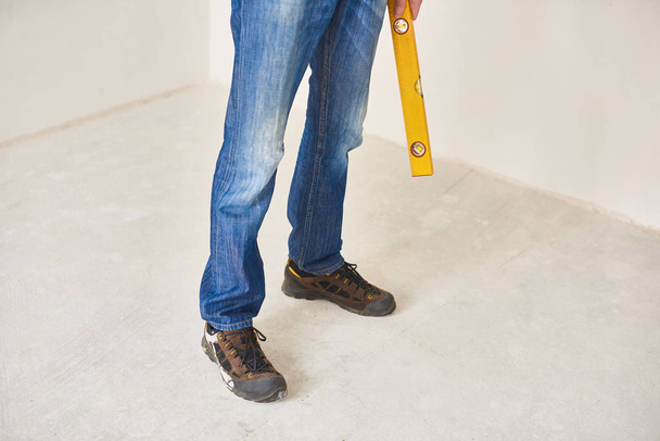 Man using a spirit level to plumb a wall. Home renovation concept - Photo, Image