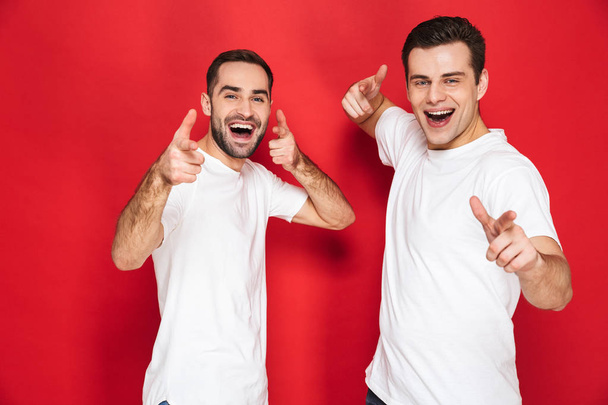 Image of two beautiful men friends 30s in white t-shirts smiling - Foto, Imagem