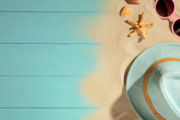 Flat lay composition with beach objects, sand and space for text on wooden background - Foto, imagen