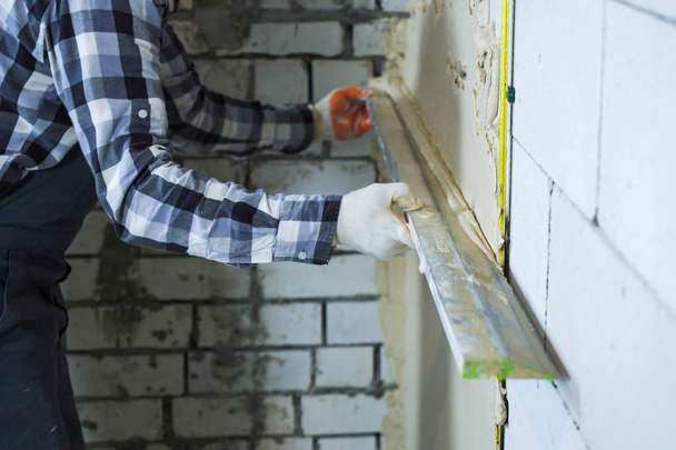 view of builder hands plastering on block wall - 写真・画像