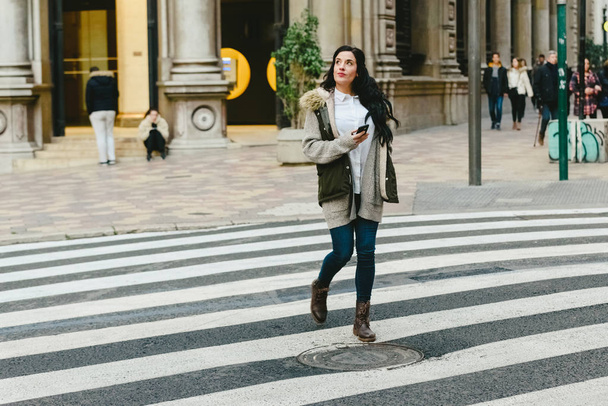 Turista mujer cruzando una calle perdida mientras consulta un mapa en h
 - Foto, imagen