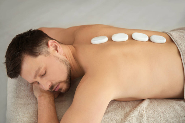 Bello uomo ricevere caldi pietra massaggio in spa salone
 - Foto, immagini